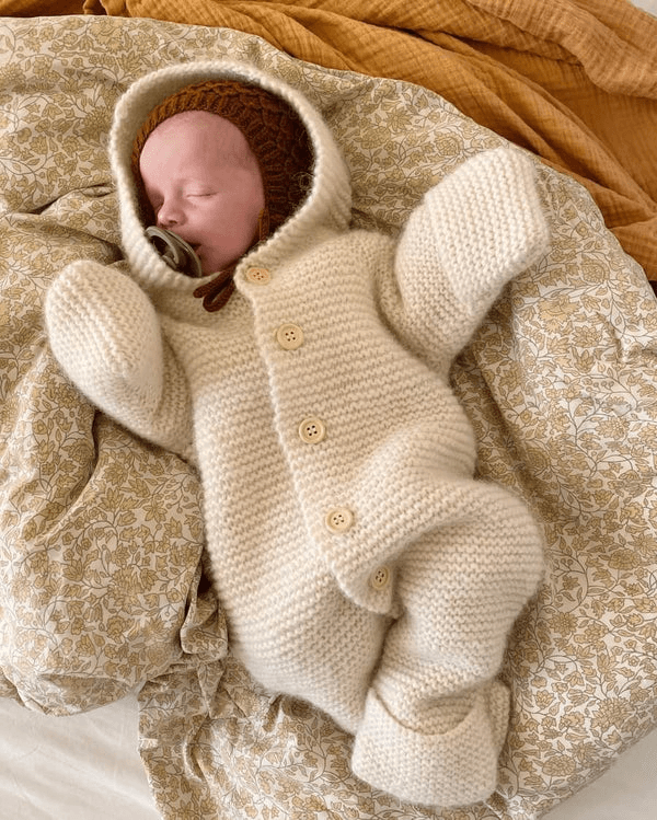valkoinen petiteknit selmas sleep suit vauvan päällä